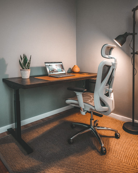Office setup with a standing desk and an ergonomic desk chair
